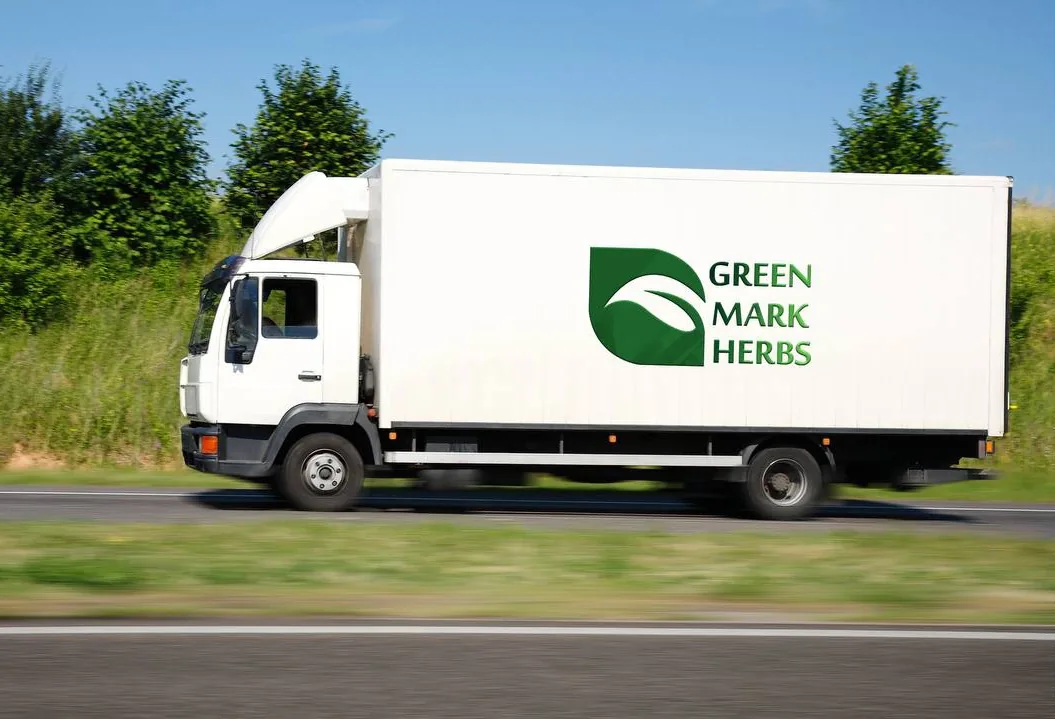 A Green Mark Herbs delivery truck on the road